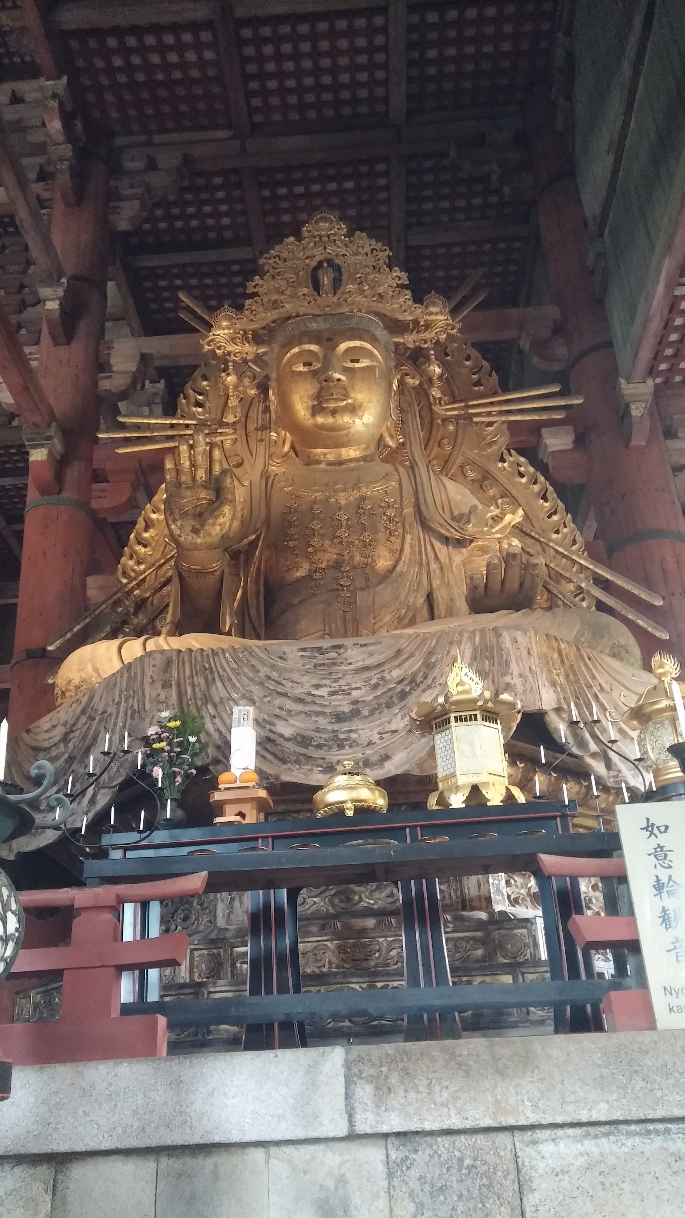 A large bronze Buddha statue inside a wooden temple