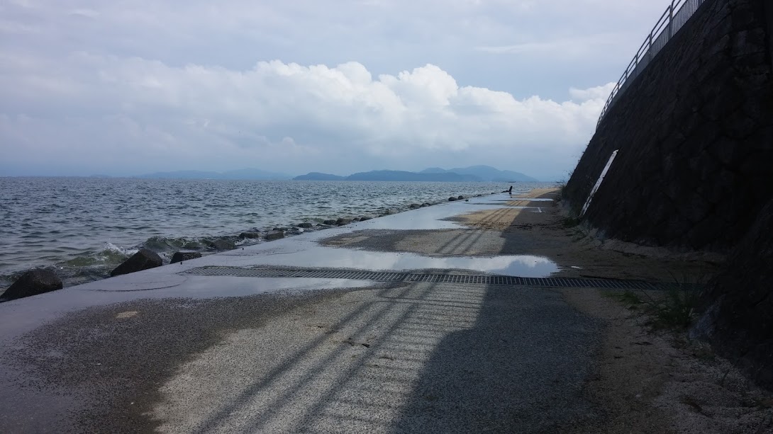 A concrete path running alongside a deep lake