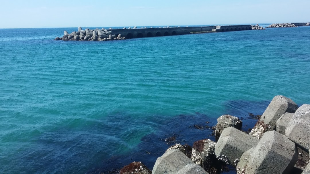 Azure blue waters and concrete wave breakers along the shoreline